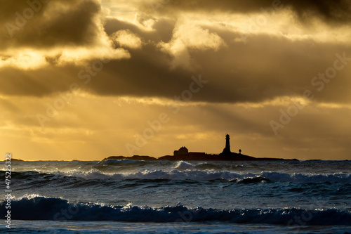 Feistein Lighthouse surrounded by the sea during a golden sunset in Rogaland county, Norway photo