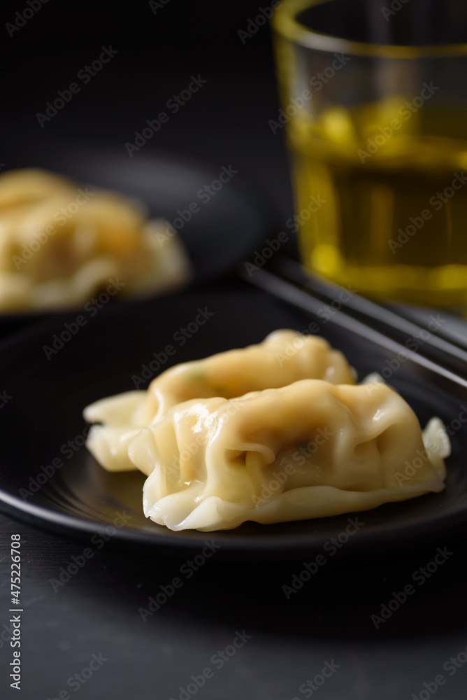 Wonton stuffed, gyoza or dumplings, Asian cultural food on black background