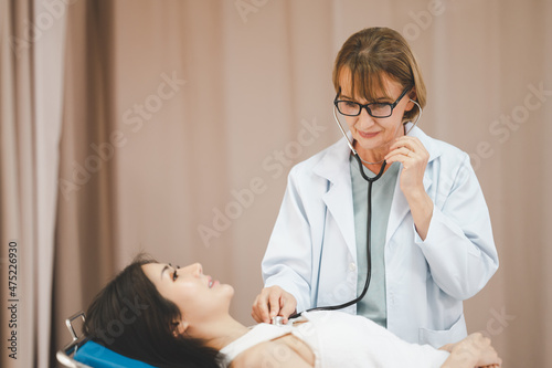 Female doctor wearing a stethoscope examines the patient s condition. concept of symptomatic treatment Health care in the hospital.