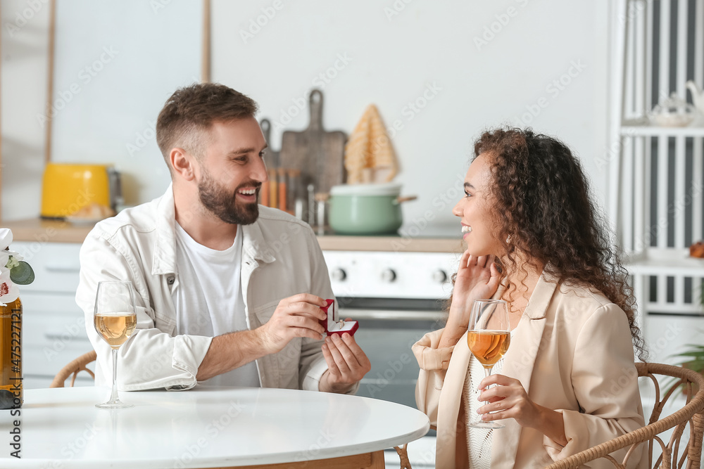 Young man proposing to his girlfriend at home Young man proposing to his girlfriend at home