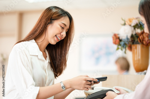 Asian women scan electronic payment channels pay online or a credit card payment machine. online payment cashless society