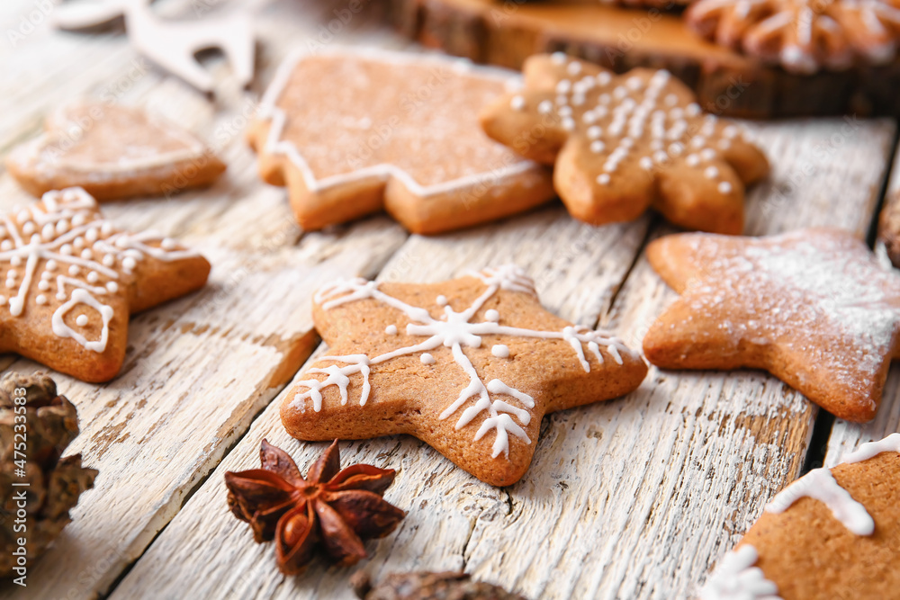 Delicious gingerbread cookies on light wooden background, closeup