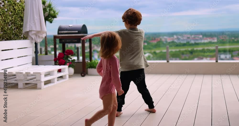 playful kids having fun on rooftop patio at summer evening at home playful kids having fun on rooftop patio at summer evening at home