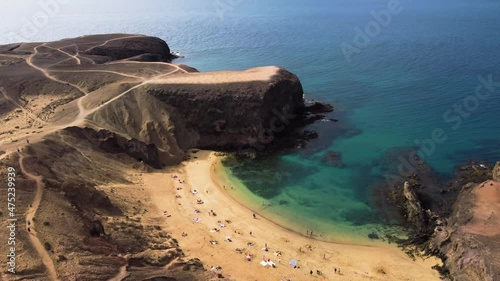 People walking down to a volcanic beach in Lanzarote, Canary Islands from a drone view. photo