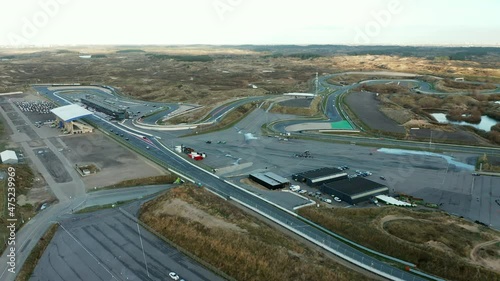 Formula One Cars Racing Down The Long Racing Track Road At Circuit Zandvoort In Netherlands. - Aerial