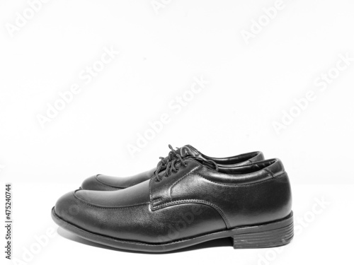 A pair of formal black shoes with laces displayed with white background 