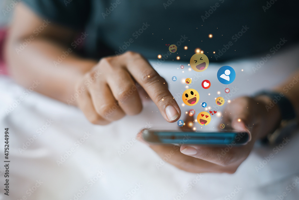 Woman playing with smartphone while laying on bed. Asian girl relaxing on bed and playing metaverse with the mobile phone. Woman playing with smartphone while laying on bed. Asian girl relaxing on bed and playing metaverse with the mobile phone.