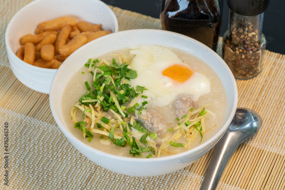 Porridge rice gruel with egg in white bowl Chinese Traditional breakfast with deep-fried dough stick. Porridge rice gruel with egg in white bowl Chinese Traditional breakfast with deep-fried dough stick.