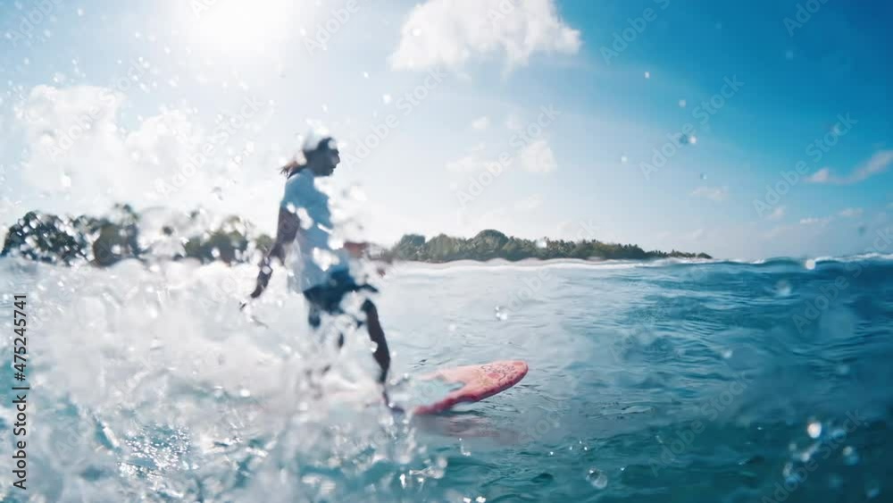 Male surfer rides the wave. Man surfs the perfect blue wave during sunny day in Maldives Male surfer rides the wave. Man surfs the perfect blue wave during sunny day in Maldives