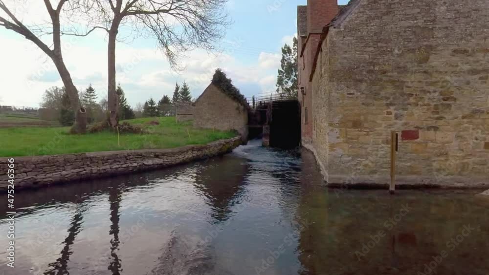 Water mill wheel working. Mill house, lower slaughter. Suburbs calm relaxing outdoors panning shot Water mill wheel working. Mill house, lower slaughter. Suburbs calm relaxing outdoors panning shot