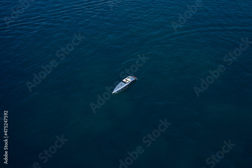 High-speed luxury boat on dark blue water. Boat performance anchorage on the water aerial view.