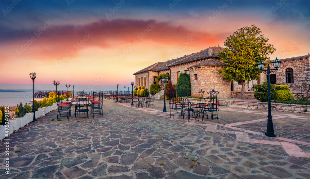 Empty tables in the yard of Lekursi Castle. Amazing morning cityscape of Saranda port. Splendid sunrise on Ionian sea, Albania, view from. Traveling concept background.