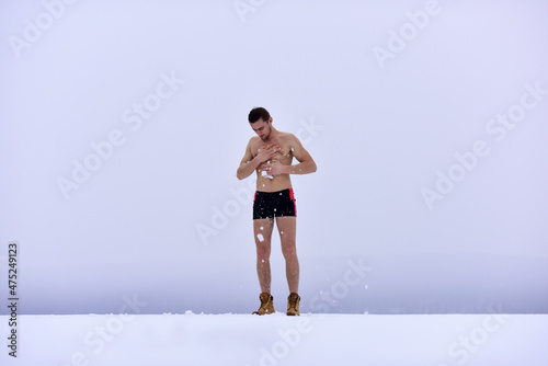 Winter fun, tempering procedures. Naked man in the snow. Guy in snow showers for the hardening of the body. Winter healthy lifestyle.