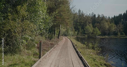 Wooden Path By Kypesjön Lake in Borås Sweden on Late Summer Afternoon - Wide Shot Tracking Forward photo