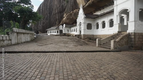 Slow motion forward going shot of Dambulla cave temple in Dambulla town of Sri Lanka, above a mountain hill where the place is empty with no people. photo
