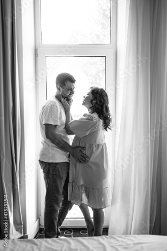 man and a pregnant woman's by the window.  © andrey