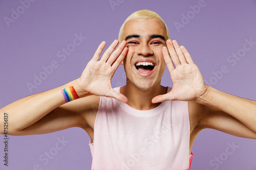 Fotobehang Young fun latin gay man with make up wear bright pink top hold hands near mouth speak shout scream coming out isolated on plain pastel purple background studio People lifestyle fashion lgbtq concept
