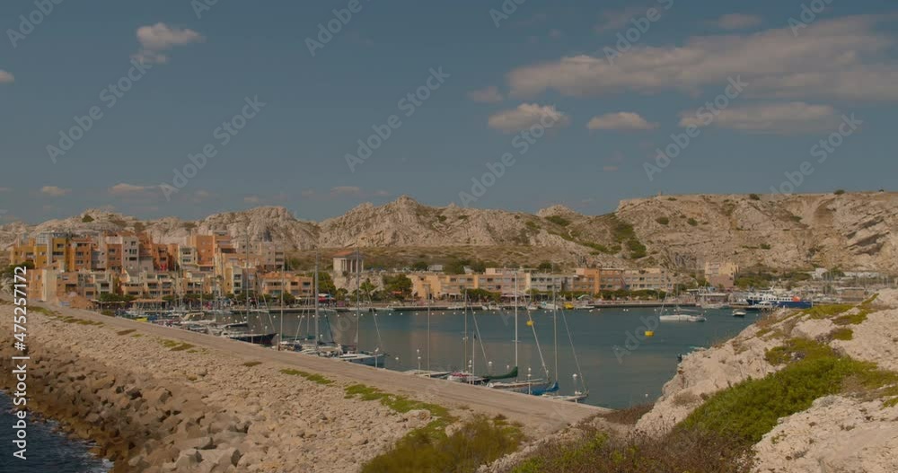 Boats Moored At Port du Frioul With Waterfront Restaurants In Marseille, France. - wide shot Boats Moored At Port du Frioul With Waterfront Restaurants In Marseille, France. - wide shot