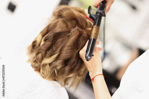 Blonde female on hairdresser appointment get curly hairstyle