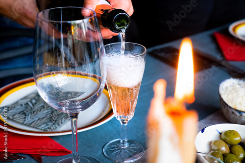 Man's hand pouring champagne to make a Kir cocktail