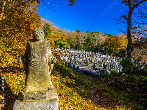 Stone statue and temple cemetery surrounded by autumn leaves  Choanji temple  Hakone  Kanagawa  Japan 