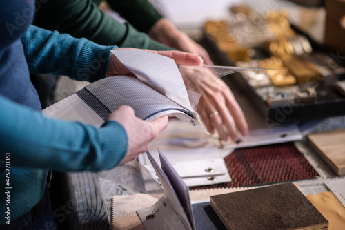 close up of hands leafing through a catalog of fabrics