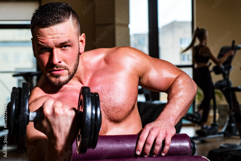 Muscular man doing crossfit. Man training with dumbbells. Dumbbell. Muscular guy exercises with dumbbells. Strong bodybuilder. Muscles with dumbbell. Muscular man doing crossfit. Man training with dumbbells. Dumbbell. Muscular guy exercises with dumbbells. Strong bodybuilder. Muscles with dumbbell.
