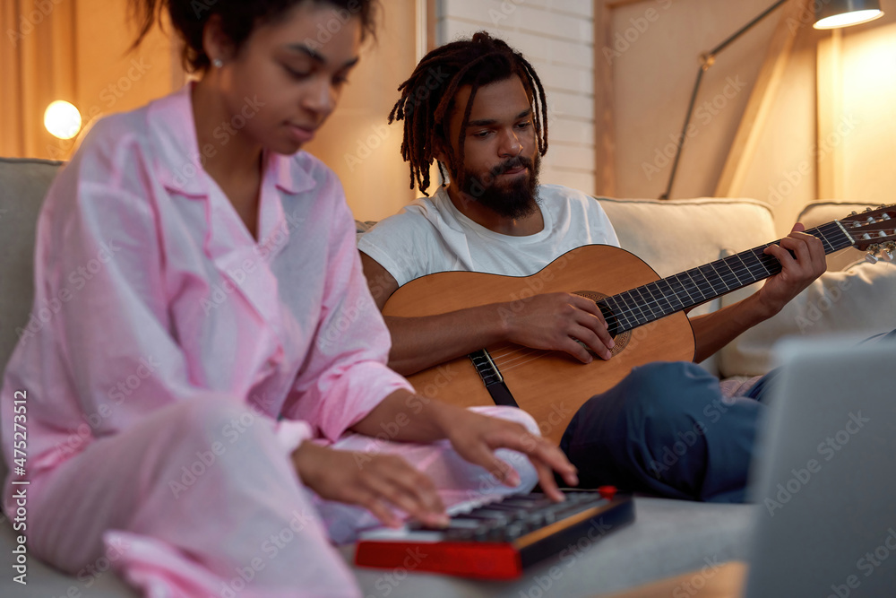 Young couple playing music at home at evening Young couple playing music at home at evening
