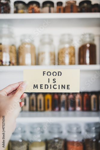 Food is Medicine text in front of tidy organised pantry with jars, dieting vs healthy nutrition and intuitive eating.