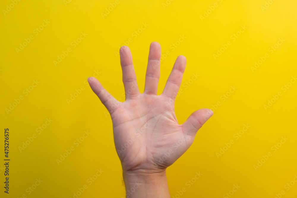 Naklejka premium close up hand on yellow background