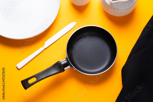 Black metal nonstick frying pan, on yellow background