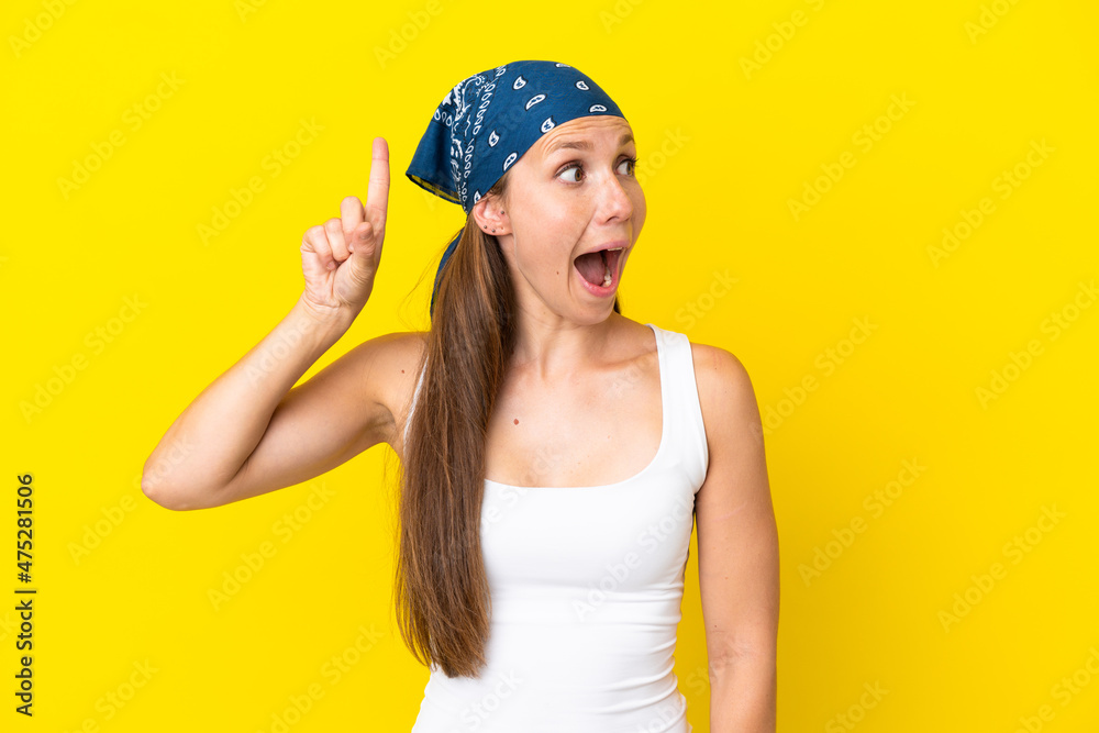 Young English woman isolated on yellow background intending to realizes the solution while lifting a finger up Young English woman isolated on yellow background intending to realizes the solution while lifting a finger up