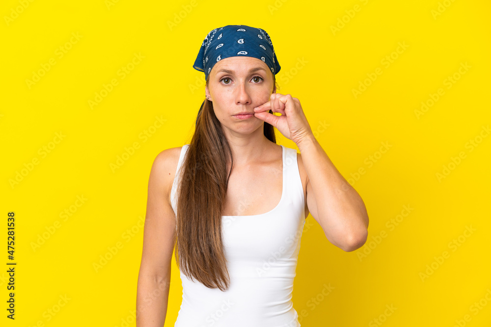 Young English woman isolated on yellow background showing a sign of silence gesture Young English woman isolated on yellow background showing a sign of silence gesture