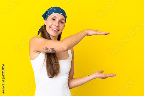 Young English woman isolated on yellow background holding copyspace to insert an ad