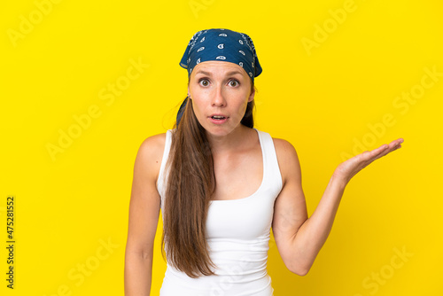 Young English woman isolated on yellow background making doubts gesture