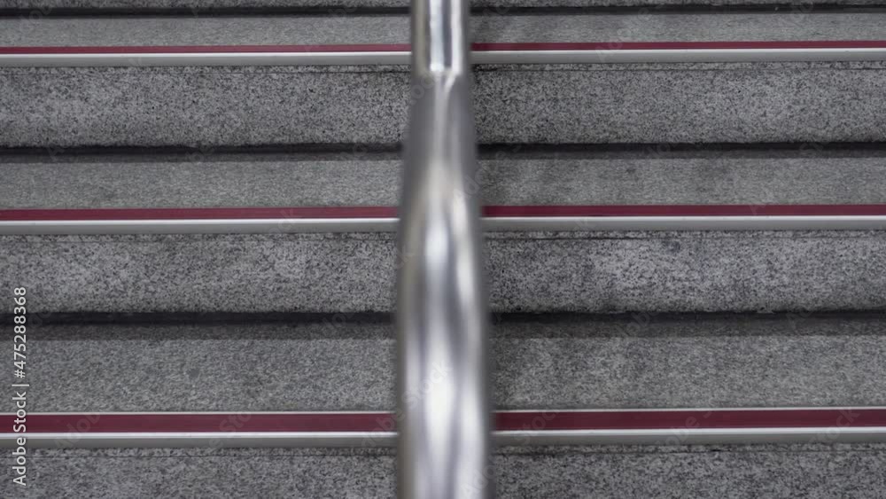 Stairs in public places. There is a metal railing in the middle of the stairs. Stairs in public places. There is a metal railing in the middle of the stairs.