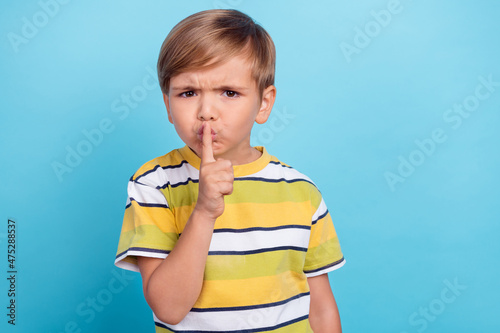 Photo of young unhappy negative upset boy hold finger lips voiceless mute isolated on blue color background