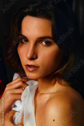 A girl in red, green and white fabrics with a mirror