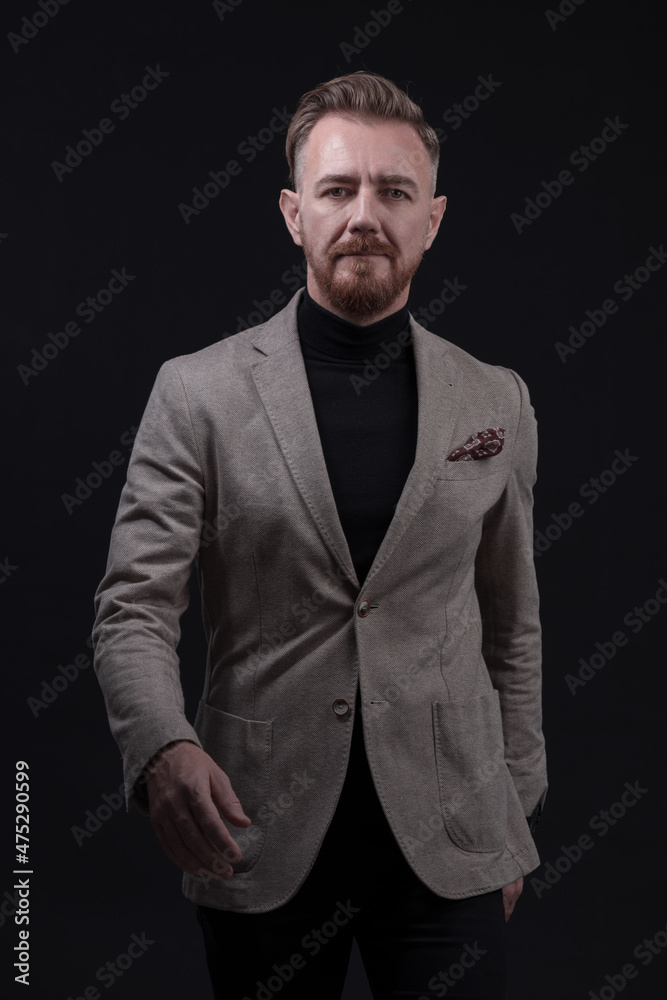 Confident businessman walking forward wearing a causal suit, handsome senior business man hero shot portrait isolated on black
