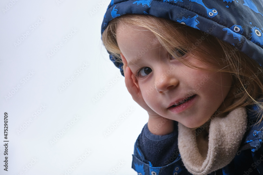 Adorable preschool girl posing with hand on her cheek isolated hood on head