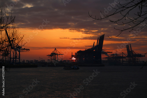 Dunkler Oranger Sonnenaufgang über den Hamburger Hafen im Herbst