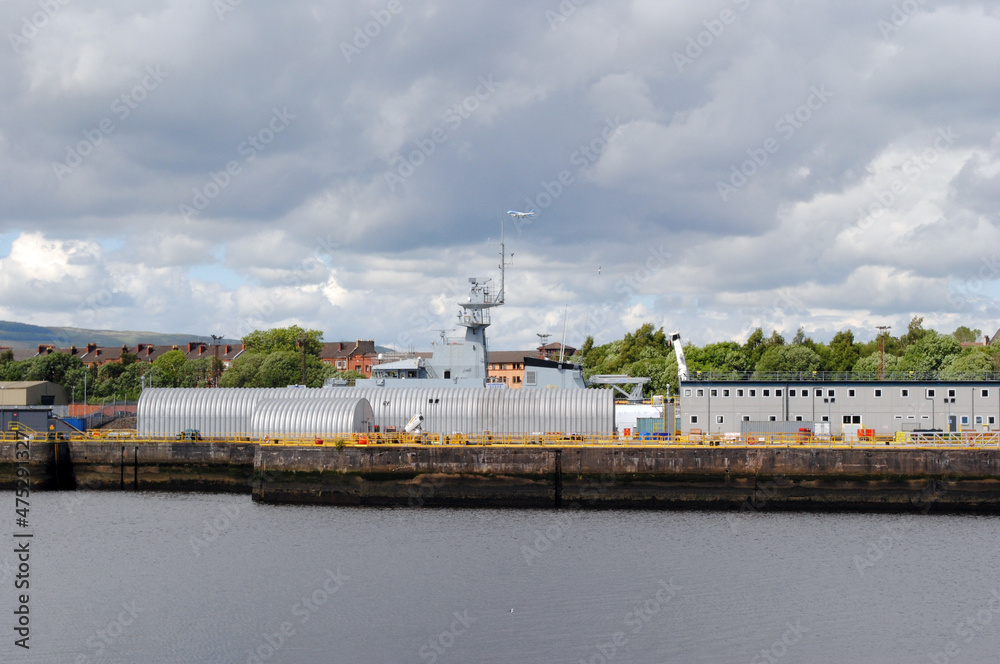 Fototapeta premium View of Riverside Industrial Dock with Naval Vessel