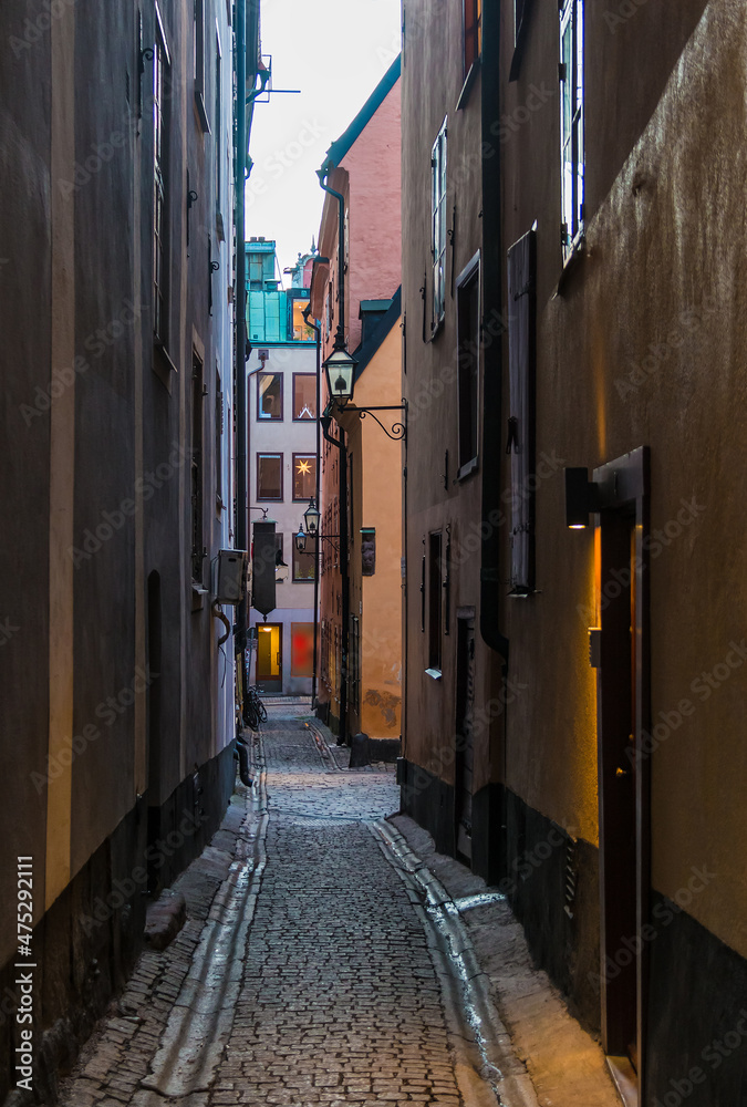 Perspective view of historical buildings on the Overskarargrand Alley in winter day, Stockholm, Sweden
