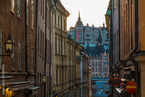 Photography Perspective view of historical buildings on the Tyska Brinken Street at sunset,