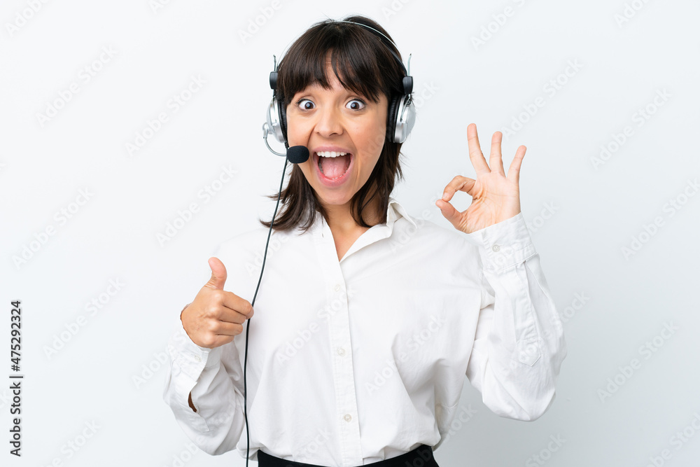 Telemarketer mixed race woman working with a headset isolated on white background showing ok sign and thumb up gesture Telemarketer mixed race woman working with a headset isolated on white background showing ok sign and thumb up gesture