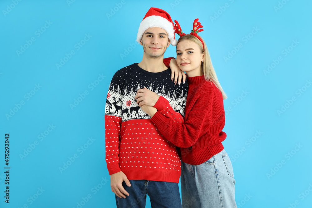 Cute couple in Christmas clothes on blue background Cute couple in Christmas clothes on blue background