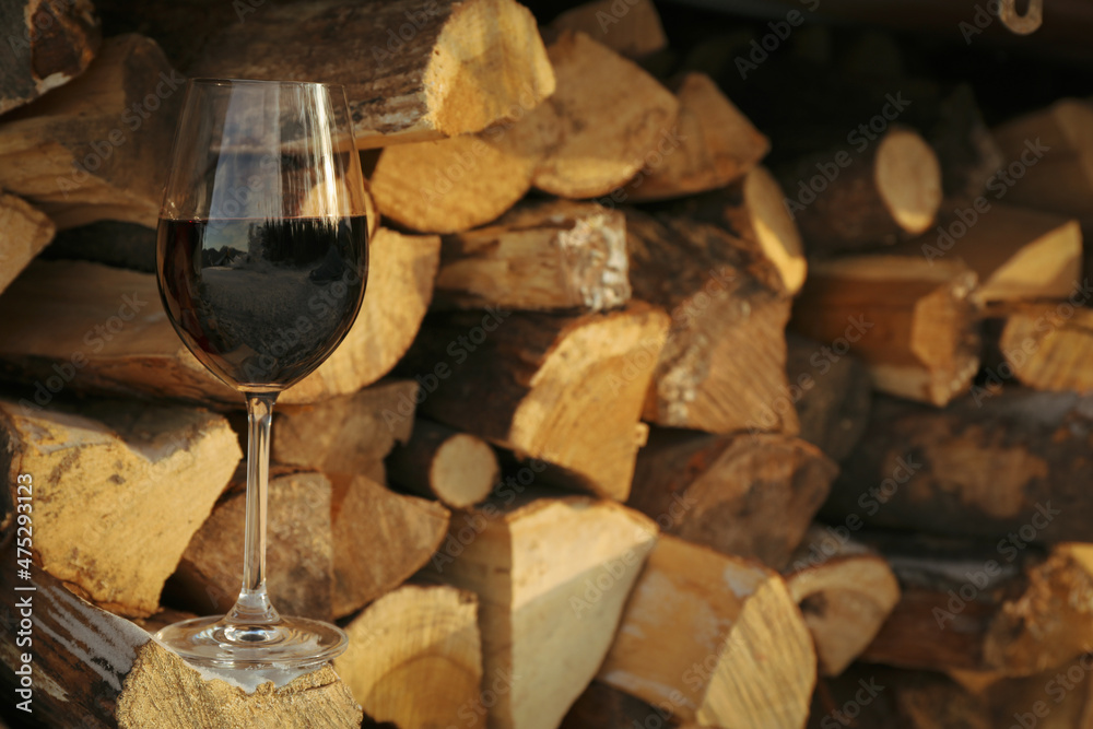 Glass of wine outdoor on folded firewood
