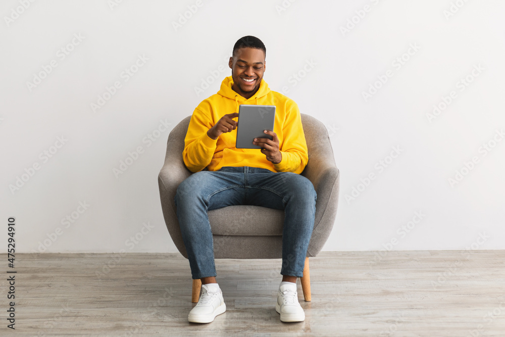 Happy Black Guy Using Digital Tablet Browsing Internet, Gray Background Happy Black Guy Using Digital Tablet Browsing Internet, Gray Background