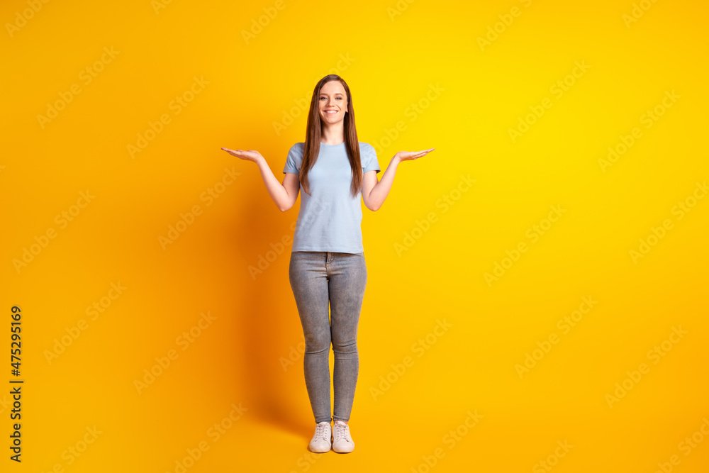 Full size hoto of young pretty girl hold hands measure scales promotion decide isolated over yellow color background Full size hoto of young pretty girl hold hands measure scales promotion decide isolated over yellow color background