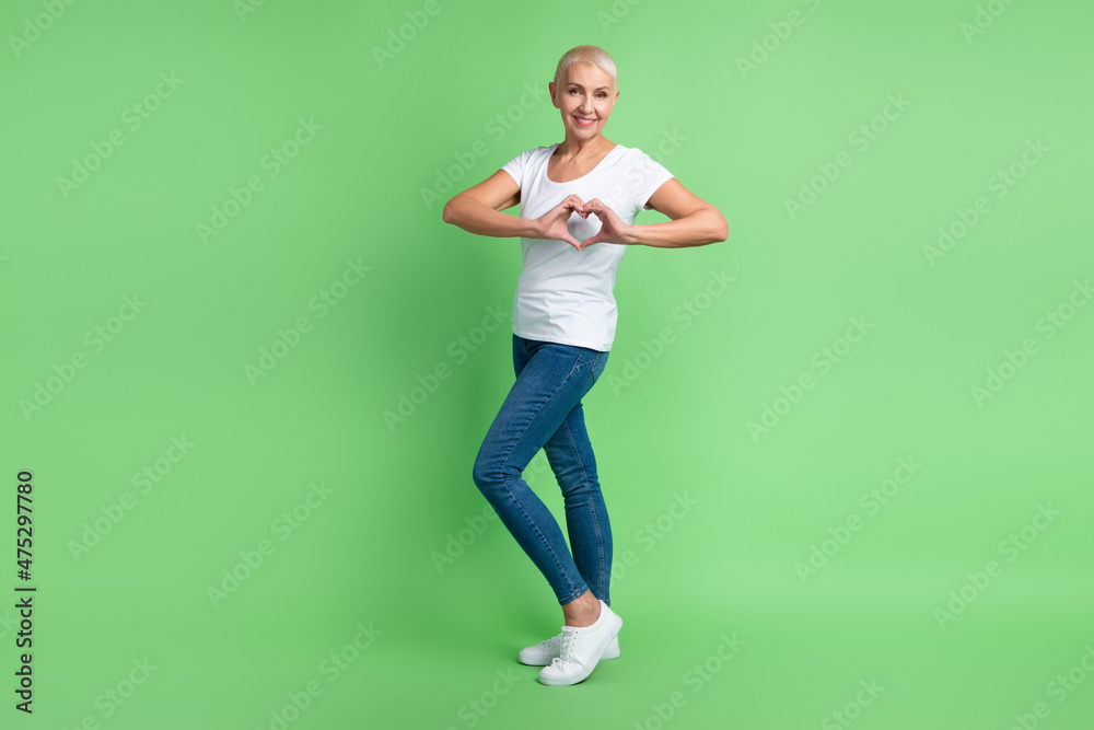 Full body profile side photo of lovely aged woman show fingers heart symbol cupid cardiac isolated over green color background